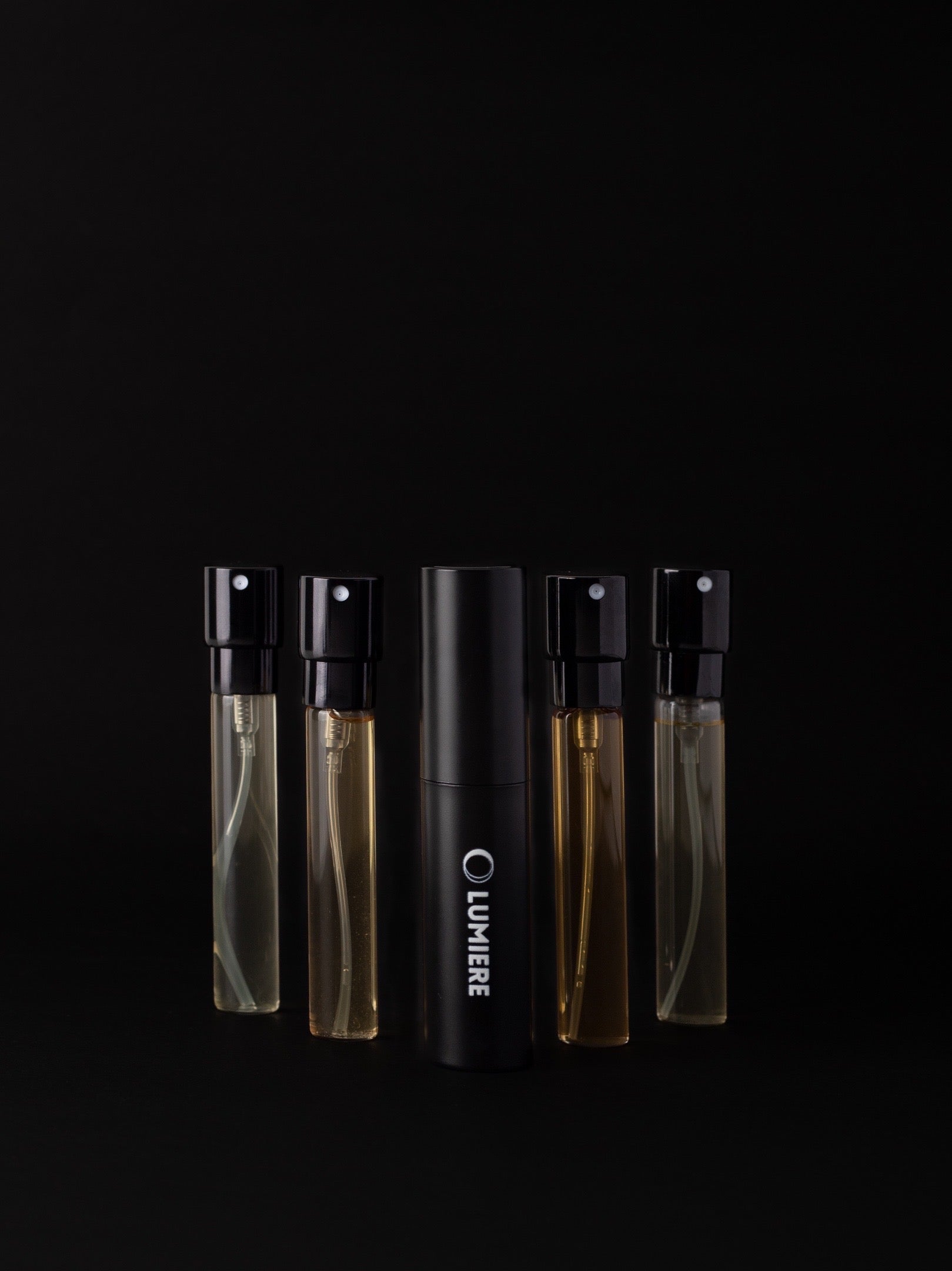 Set of perfume bottles with 'Lumiere' branding on a black background