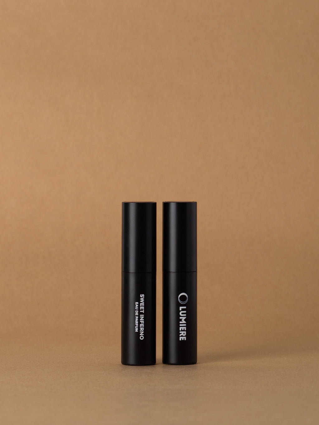 Two black cosmetic tubes with 'Olivier' branding on a brown background
